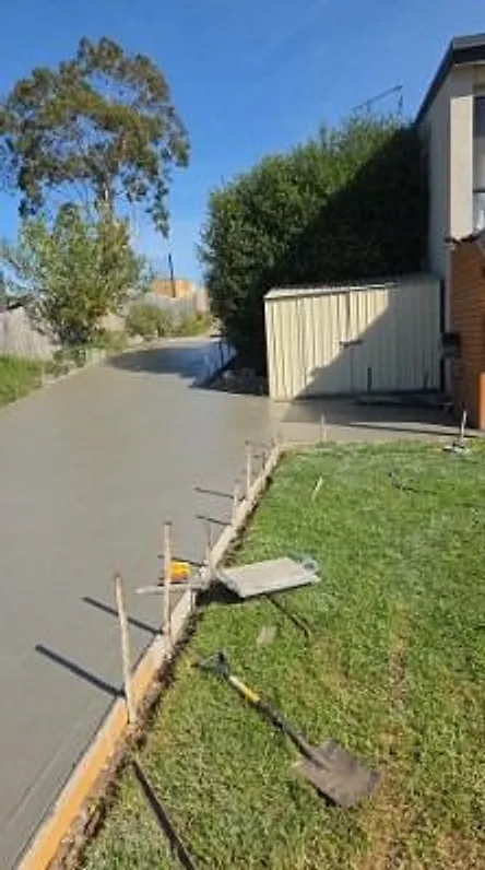 Concrete path being finished beside the lawn