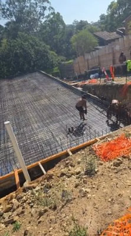 Crew tying reinforcing steel across a house slab